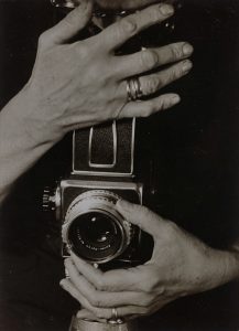 Zwei Hände halten einen historischen Fotoapparat